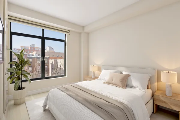 a bedroom with a large bed and a large window