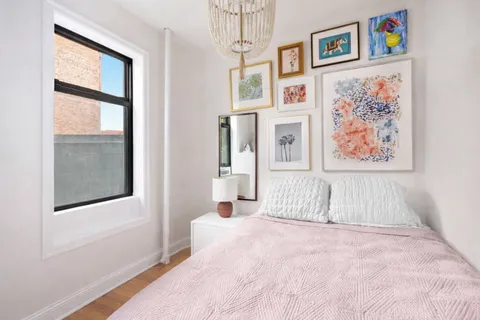 a bedroom with bed and wall painting with wooden floor