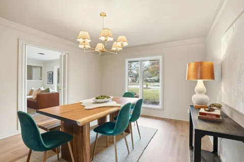 a view of a dining room with furniture a chandelier and wooden floor