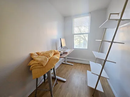 a view of a workspace with furniture and a window