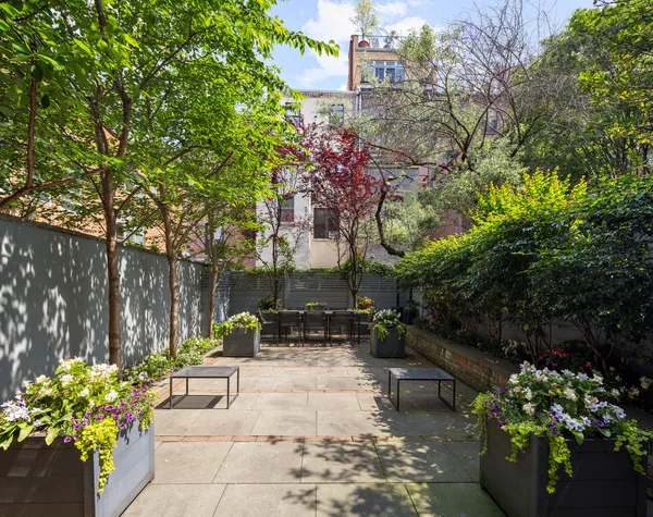a patio with table and chairs and potted plants