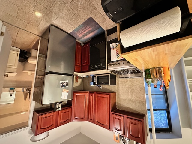 349 West 45th Street, Unit 3RE Manhattan, NY 10036 - Photo 3 of 5 a kitchen with stainless steel appliances granite countertop a refrigerator and a stove