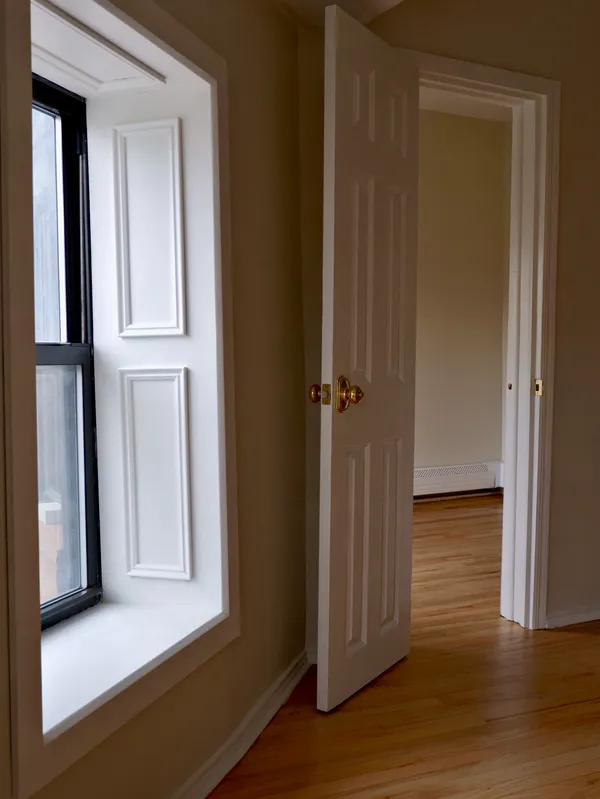 a view of a hallway with wooden floor