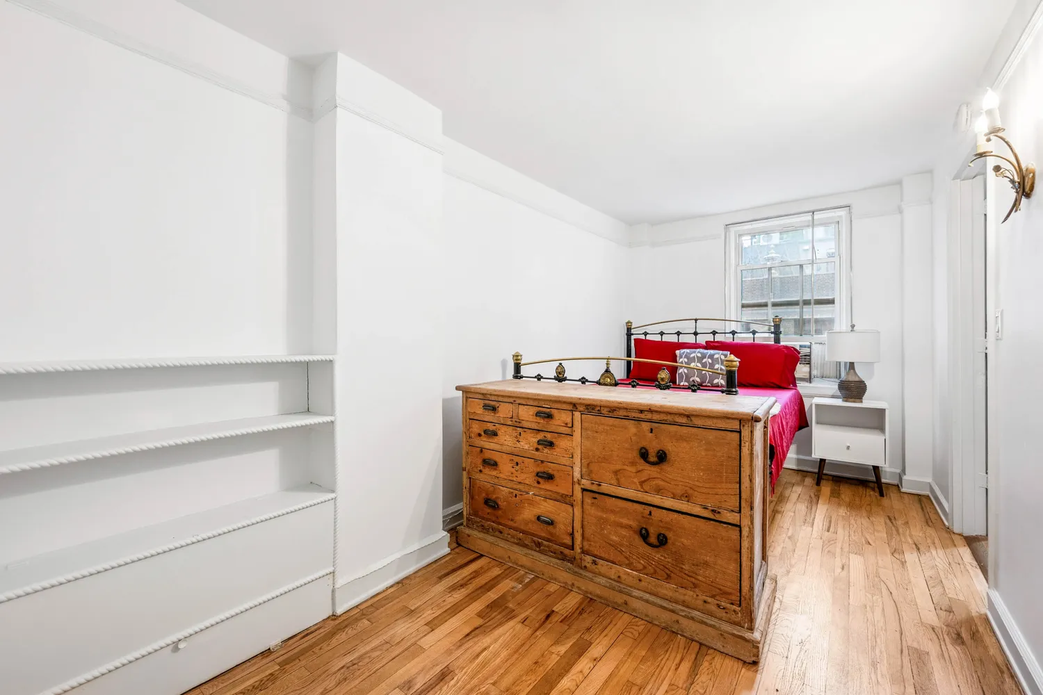 a view of a bedroom with baby crib and wooden floor