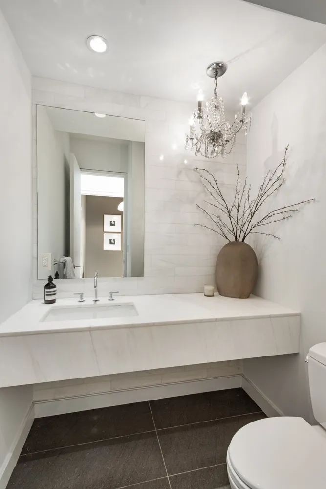 a bathroom with a sink a toilet and mirror
