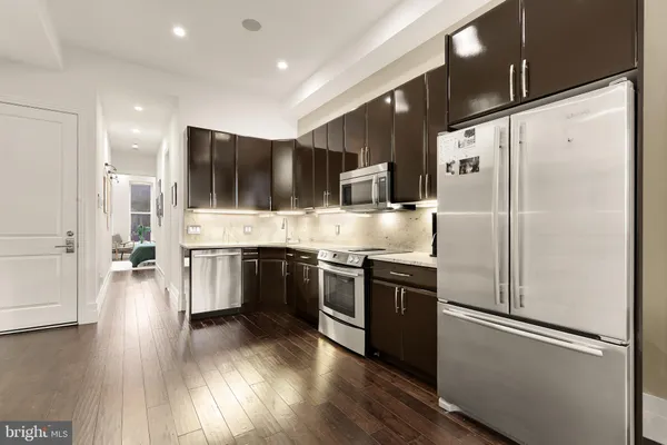 a kitchen with stainless steel appliances a refrigerator sink and microwave