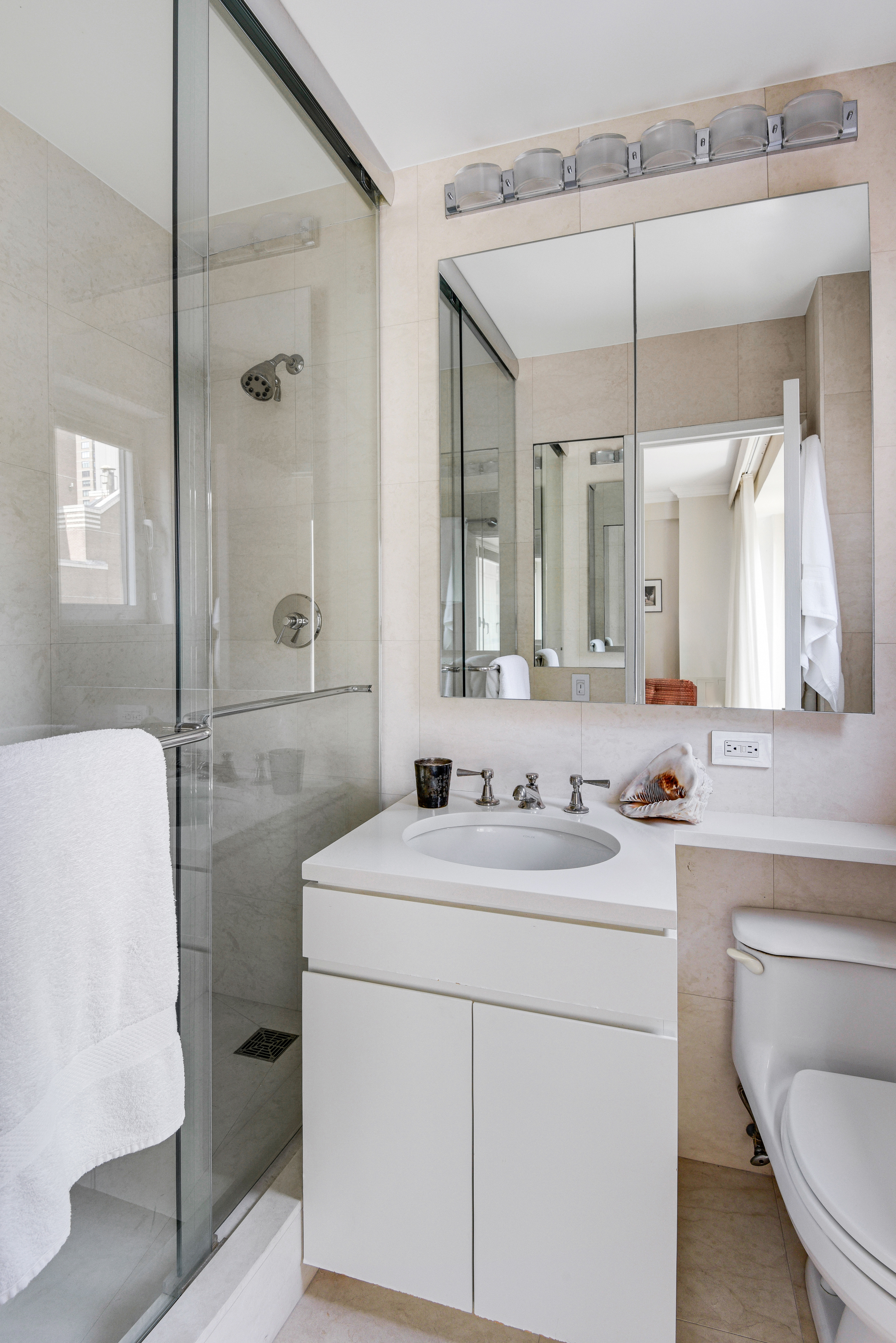 200 Central Park South, Unit 19J Manhattan, NY 10019 - Photo 11 of 12 a bathroom with a sink a toilet and mirror