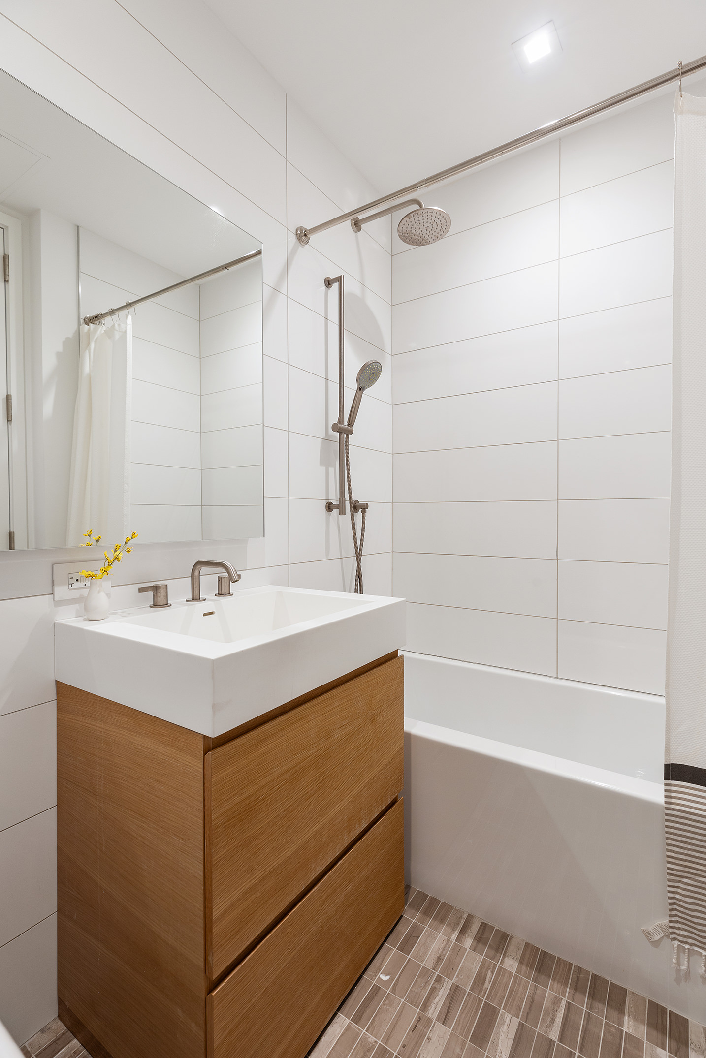 98 Front Street, Unit PH3G Brooklyn, NY 11201 - Photo 8 of 12 a bathroom with a sink mirror and a bathtub