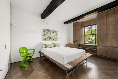 a bedroom with a bed table and a window