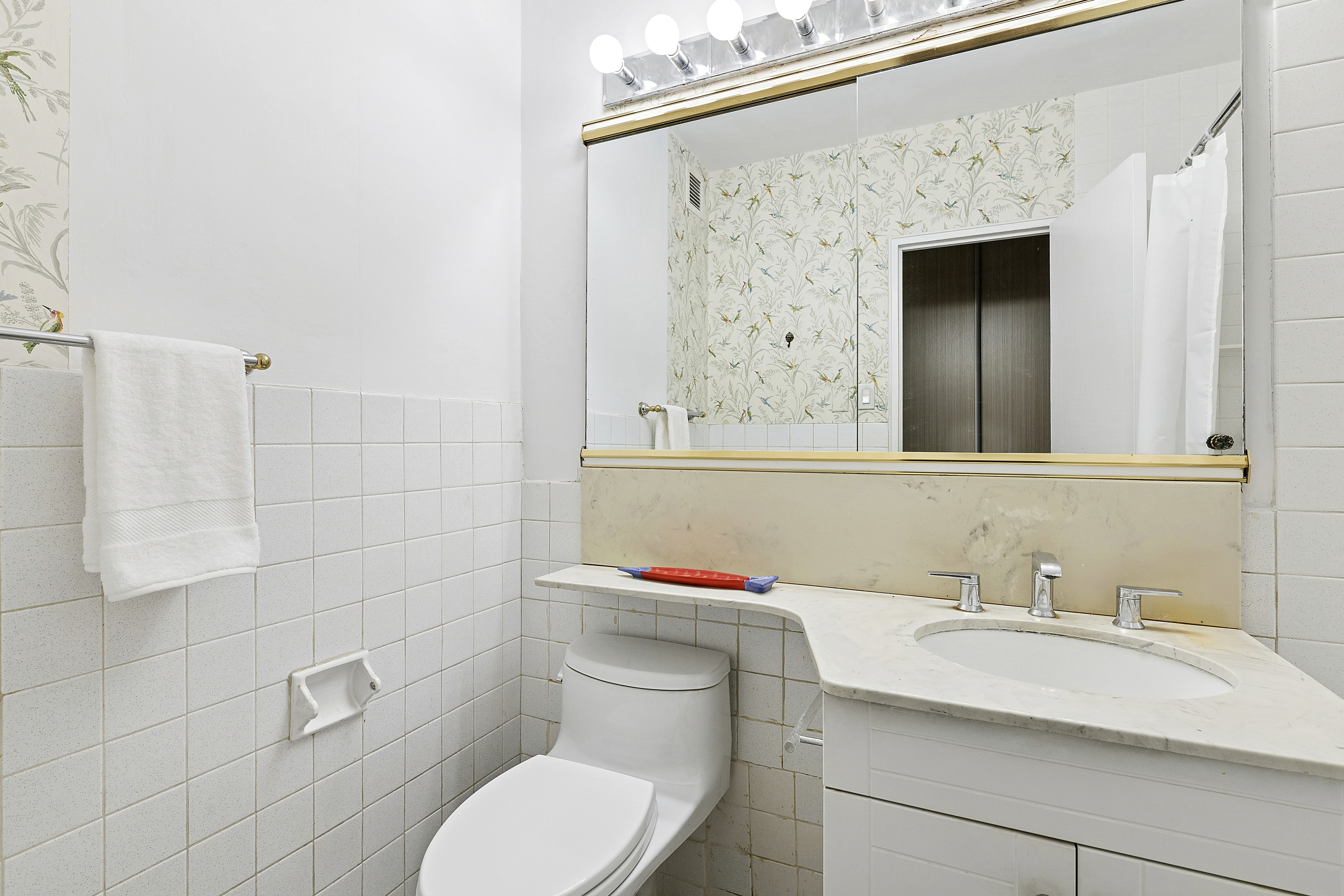 400 East 56th Street, Unit 4R Manhattan, NY 10022 - Photo 6 of 9 a bathroom with a sink a toilet and shower