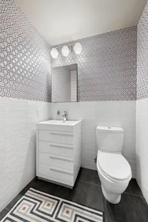 a bathroom with a sink a toilet a mirror and shower