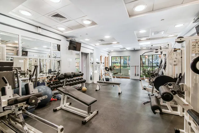 a room with gym equipment and wooden floor