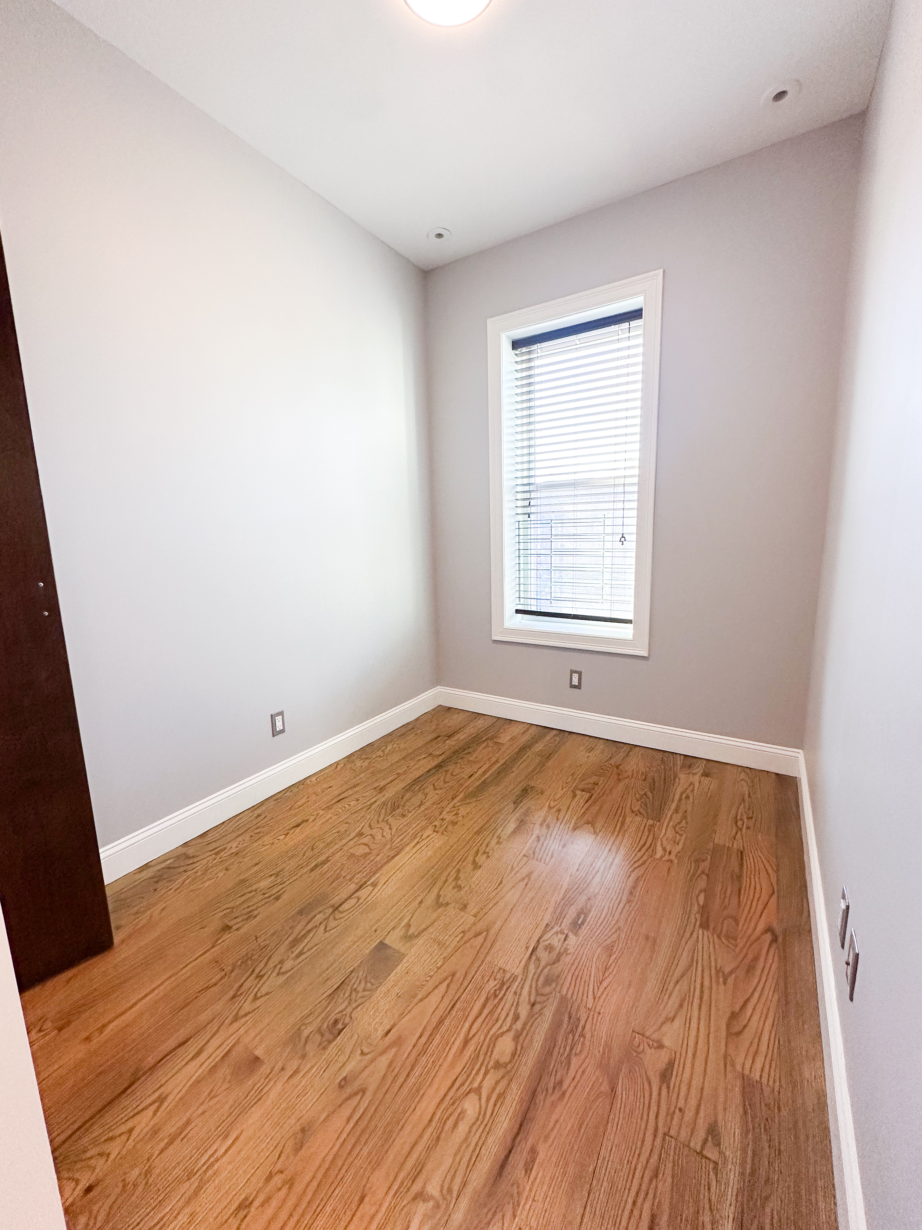 567 New Jersey Avenue, Unit 2 Brooklyn, NY 11207 - Photo 9 of 11 an empty room with wooden floor and windows
