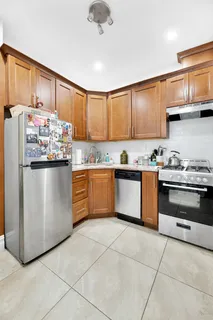 a kitchen with stainless steel appliances granite countertop a stove top oven a sink dishwasher and a refrigerator