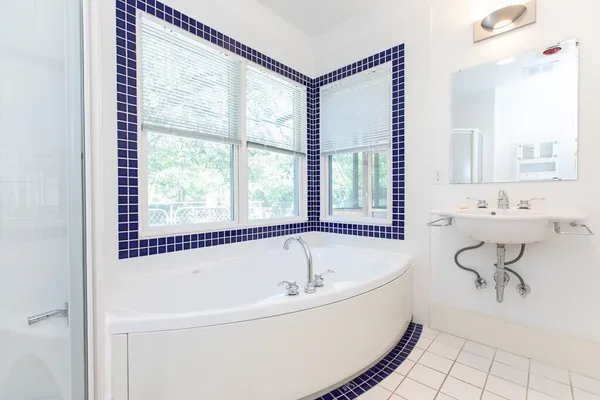 a white bath tub sitting next to a bathroom sink