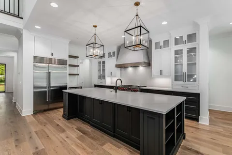 a kitchen with cabinets wooden floor and stainless steel appliances