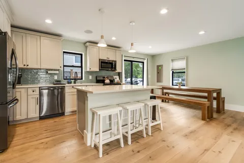 a kitchen with stainless steel appliances a refrigerator a sink a stove and cabinets