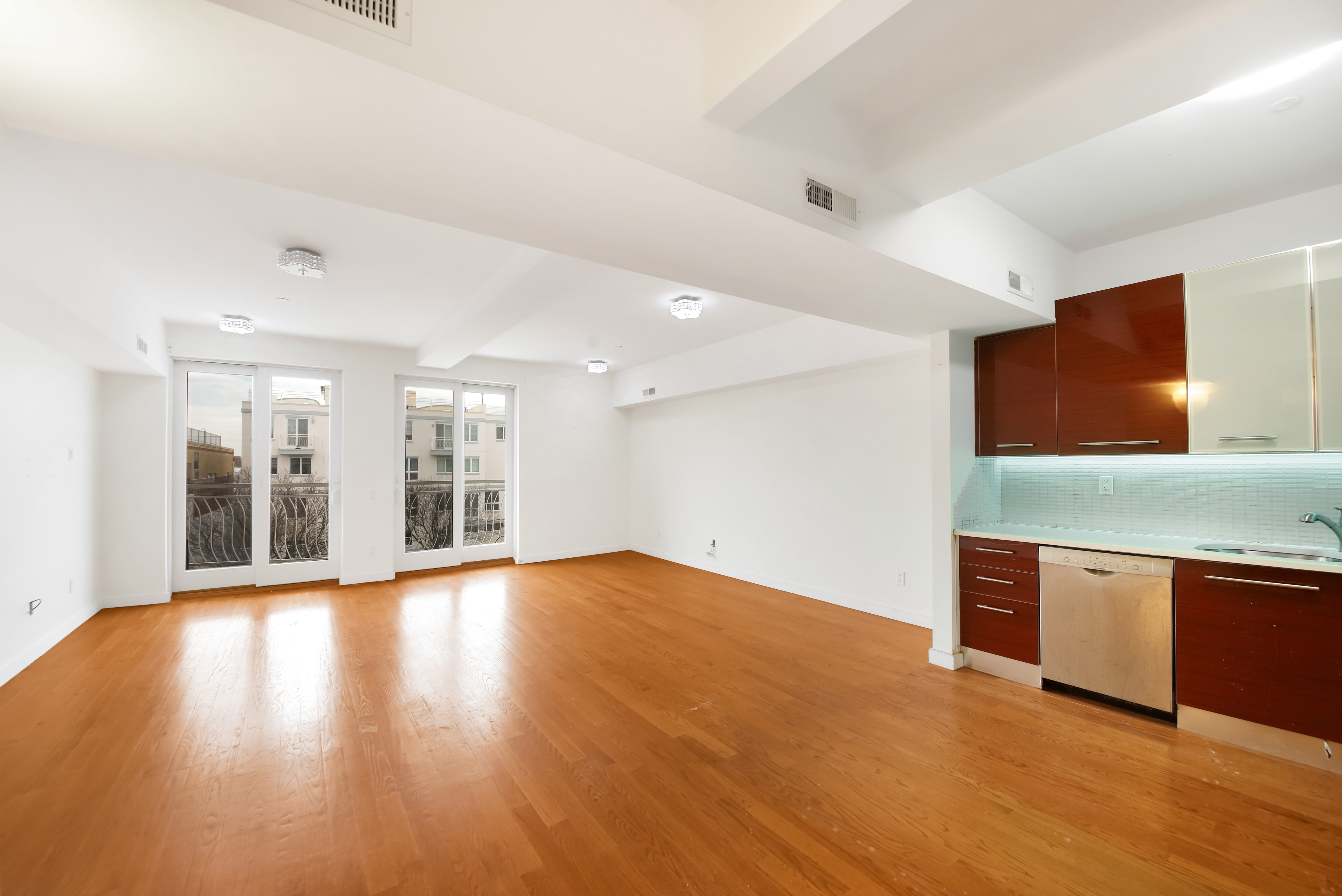 3112 Emmons Avenue, Unit 206 Brooklyn, NY 11235 - Photo 3 of 10 a view of an empty room with wooden floor and a window