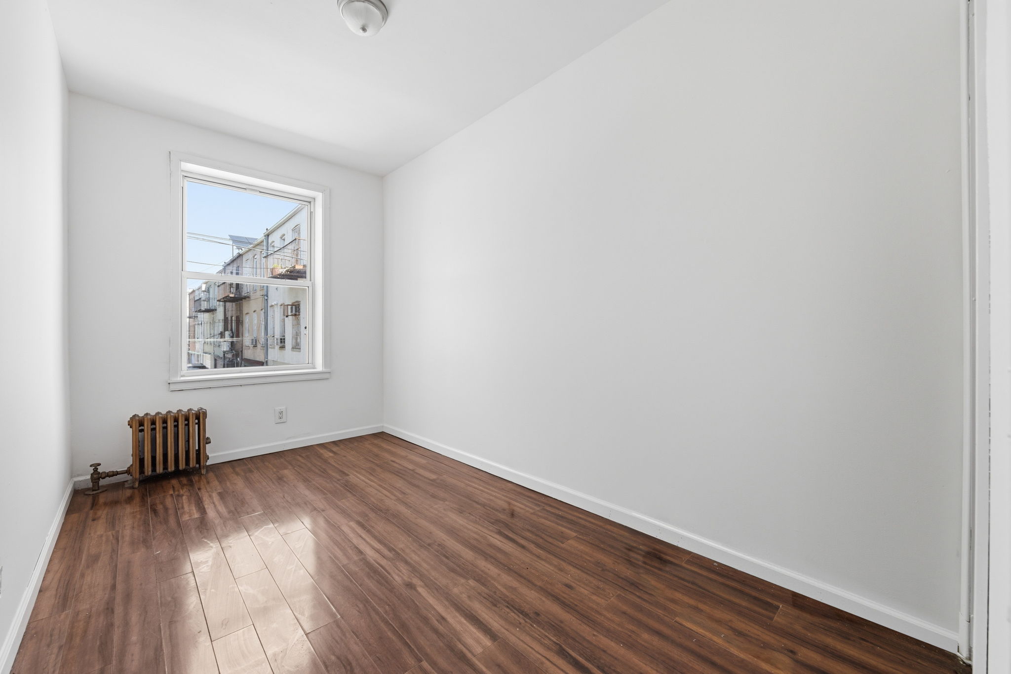 37 Chester Avenue Brooklyn, NY 11218 - Photo 7 of 14 a view of empty room with wooden floor and fan