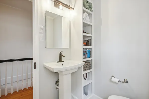a bathroom with a sink a toilet and mirror