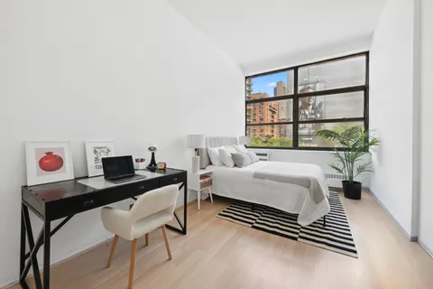 a bedroom with a bed and a large window