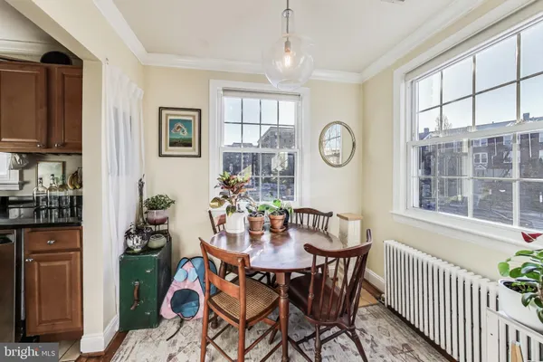 a dining room with furniture potted plants and wooden floor