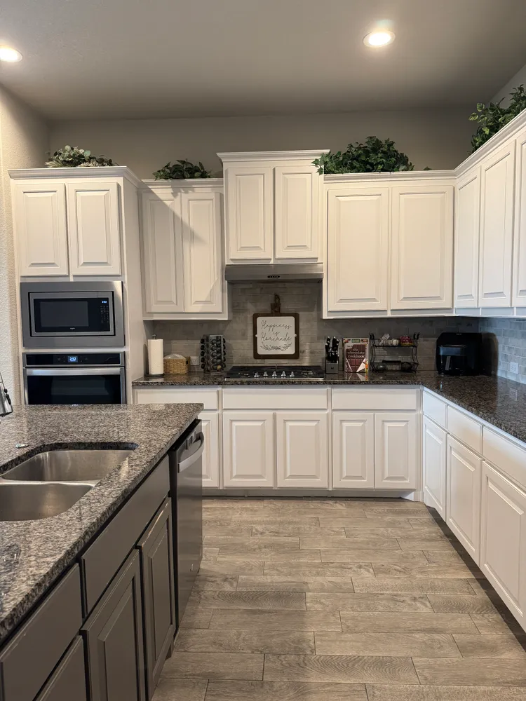 a kitchen with granite countertop a sink a stove and cabinets