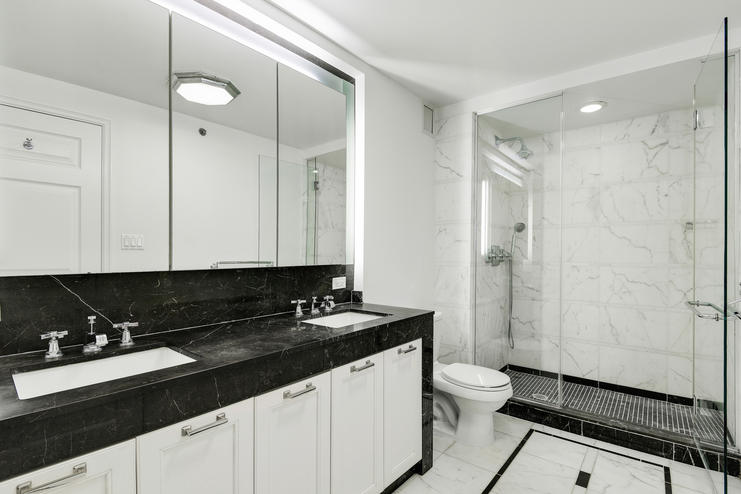 205 East 85th Street, Unit 12H Manhattan, NY 10028 - Photo 13 of 19 a bathroom with a double sink a toilet a mirror and shower