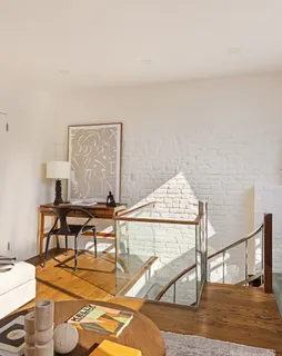 a view of a workspace with furniture and wooden floor
