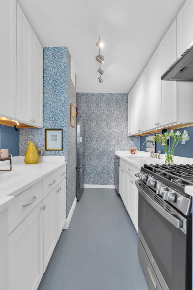 a kitchen with stainless steel appliances a sink stove and cabinets