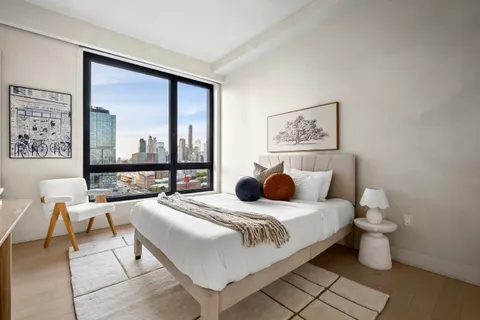 a bedroom with a bed and a large window