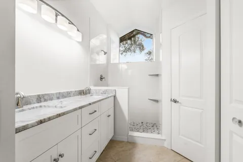 a bathroom with a granite countertop sink a mirror and a shower
