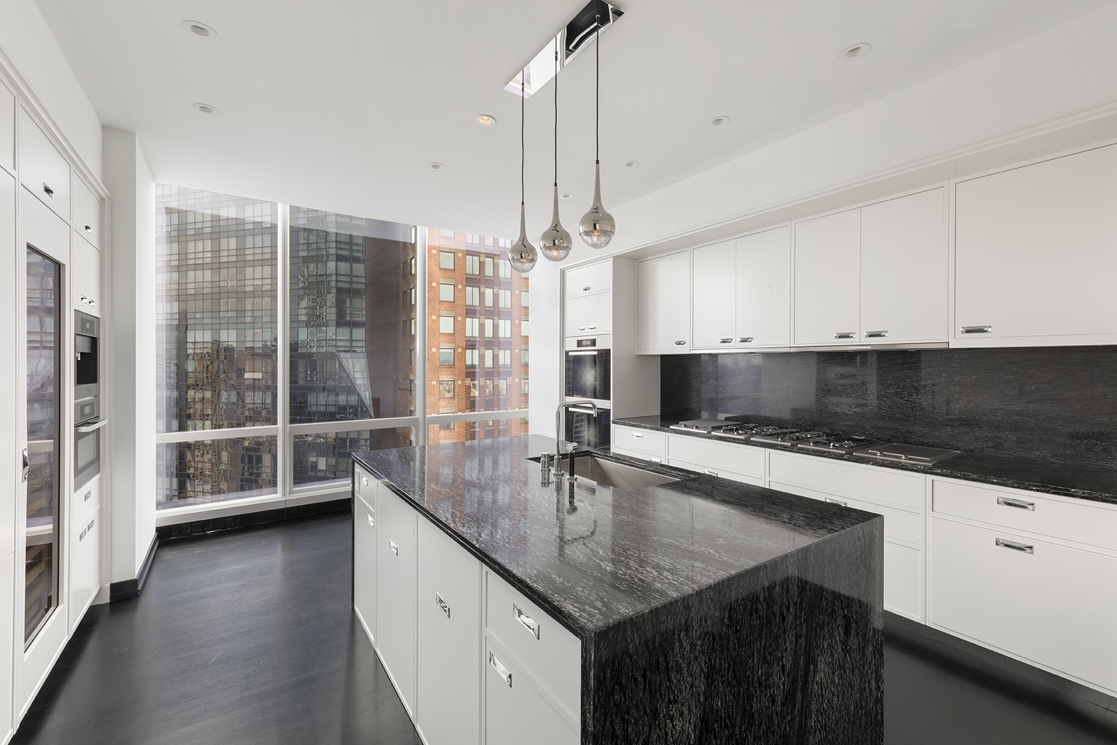 157 West 57th Street, Unit 56C Manhattan, NY 10019 - Photo 5 of 12 a kitchen with stainless steel appliances a sink stove and cabinets