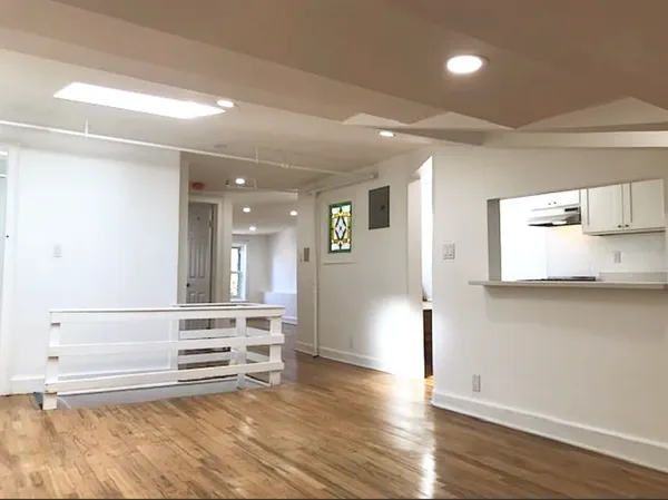 a view of a kitchen with wooden floor and electronic appliances