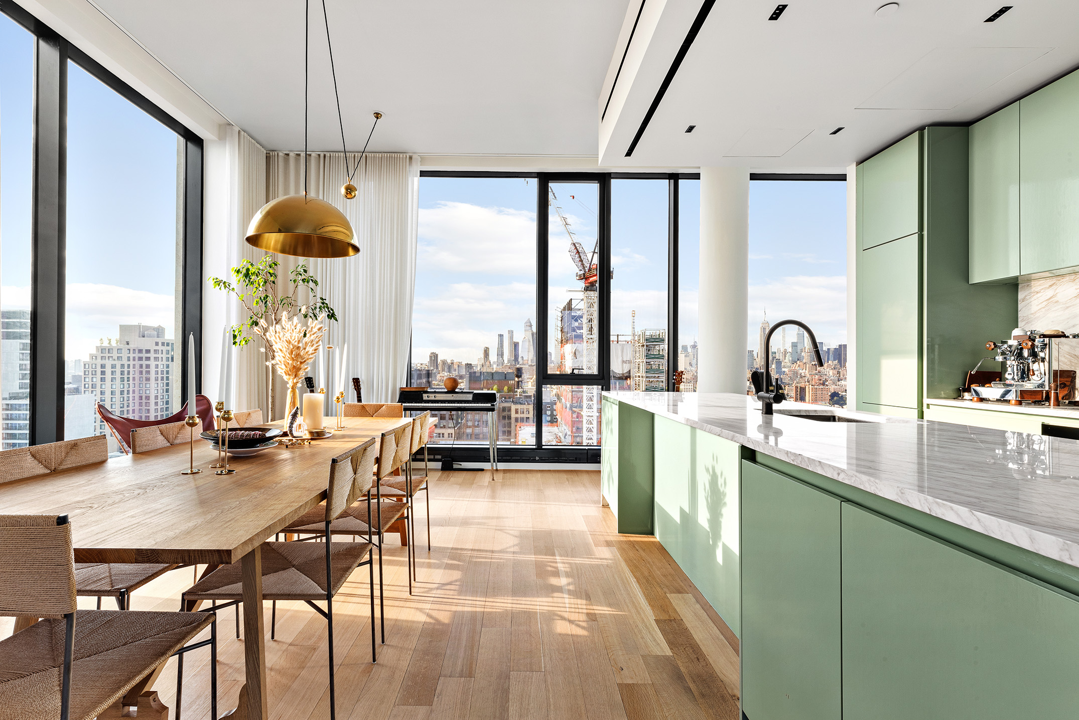 570 Broome Street, Unit PHA Manhattan, NY 10013 - Photo 3 of 22 a kitchen with sink a table and chairs in wooden floor