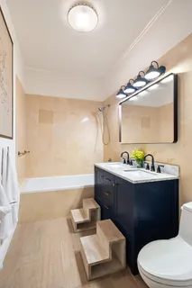 a bathroom with a bathtub sink mirror vanity and toilet