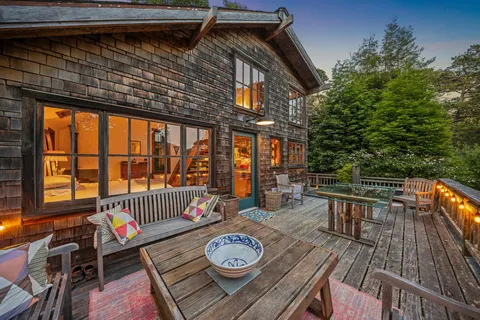 a balcony with wooden floor table and chairs