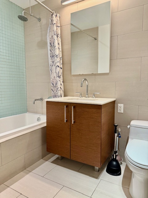 21-45 44th Drive, Unit 1H Queens, NY 11101 - Photo 4 of 7 a bathroom with a sink a toilet and bathtub