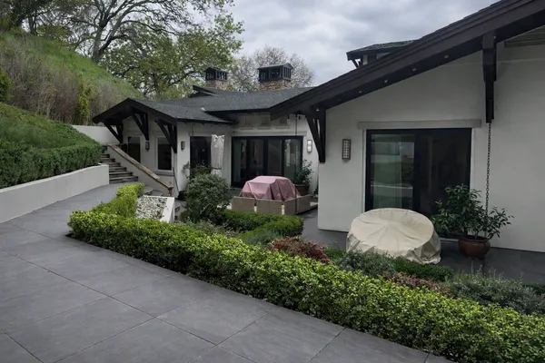 a view of a patio with couches table and chairs and potted plants