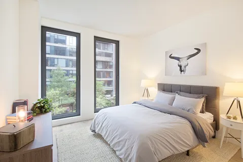 a bedroom with a large bed and a potted plant