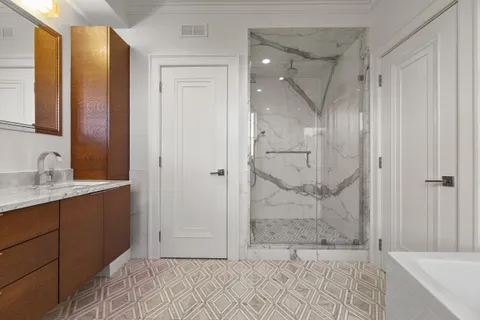 a bathroom with a granite countertop sink mirror and shower