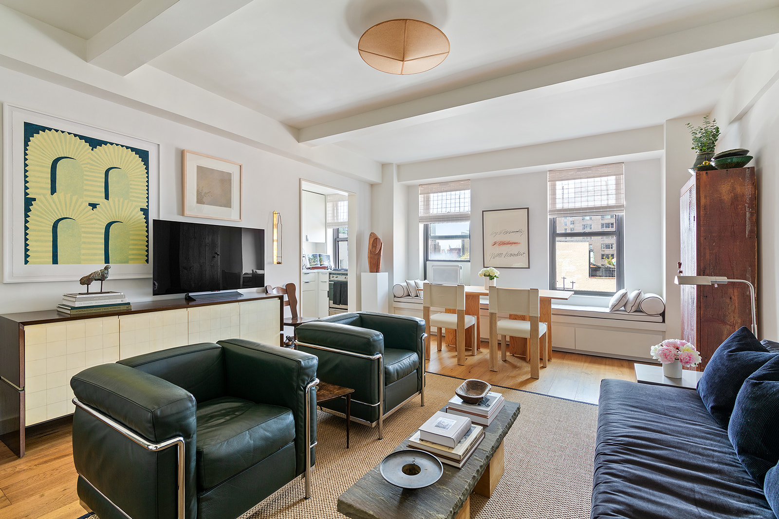 161 West 16th Street, Unit 12D Manhattan, NY 10011 - Photo 1 of 8 a living room with furniture a flat screen tv and a window
