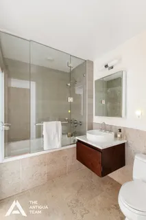 a spacious bathroom with a bathtub shower sink mirror and toilet