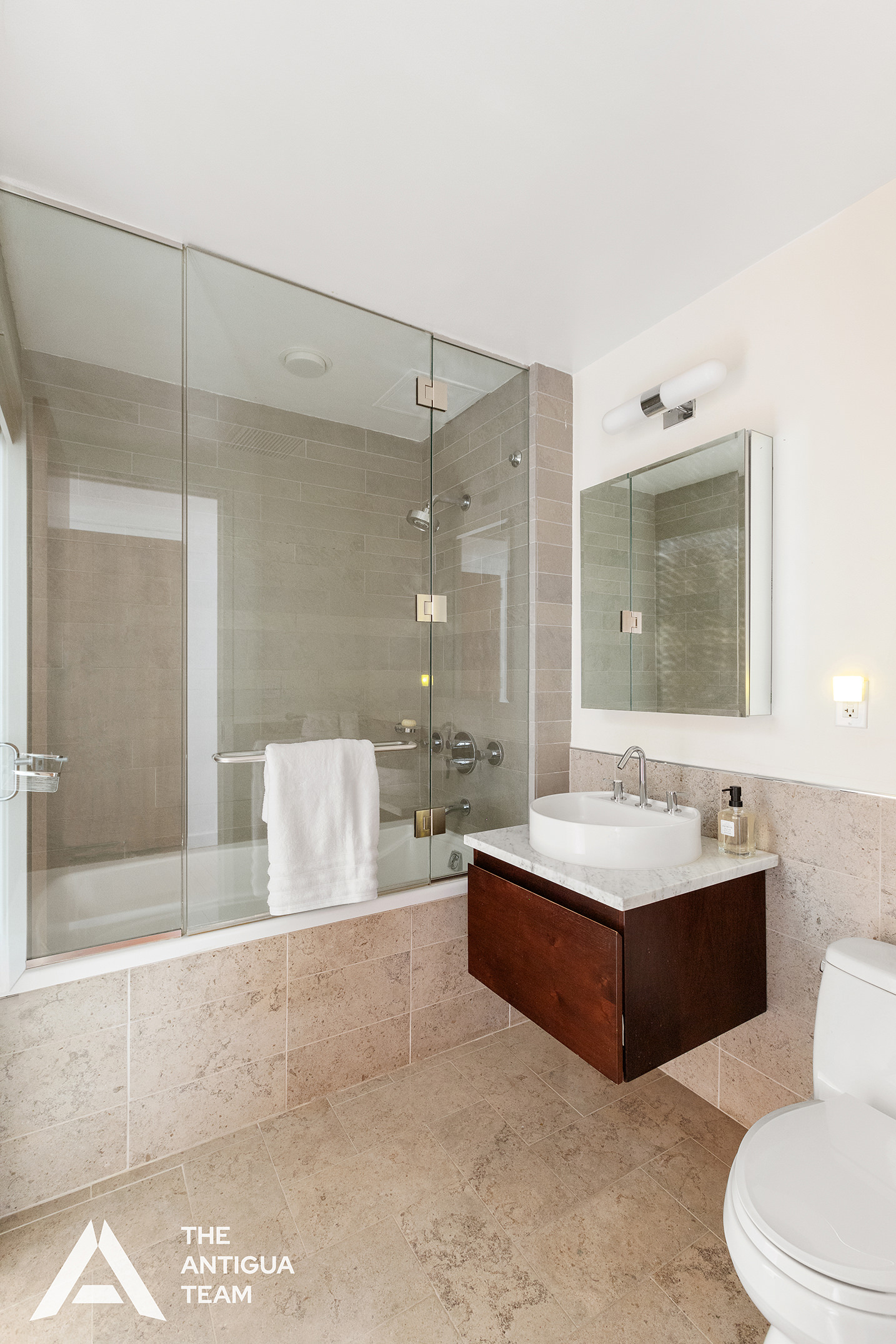 125 West 21st Street, Unit 12A Manhattan, NY 10011 - Photo 13 of 16 a spacious bathroom with a bathtub shower sink mirror and toilet
