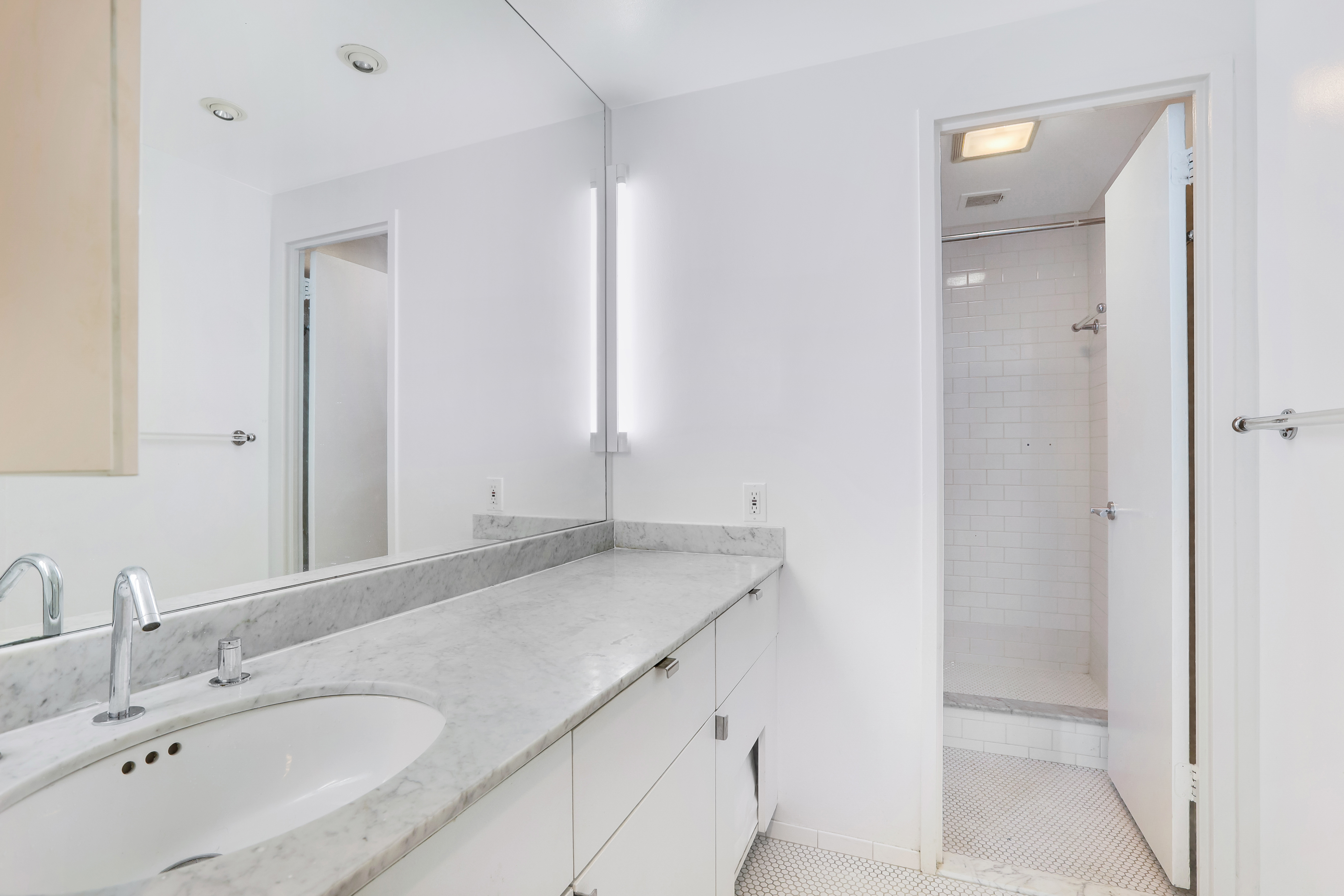 344 West 23rd Street, Unit 1E Manhattan, NY 10011 - Photo 8 of 18 a bathroom with a granite countertop sink and a mirror