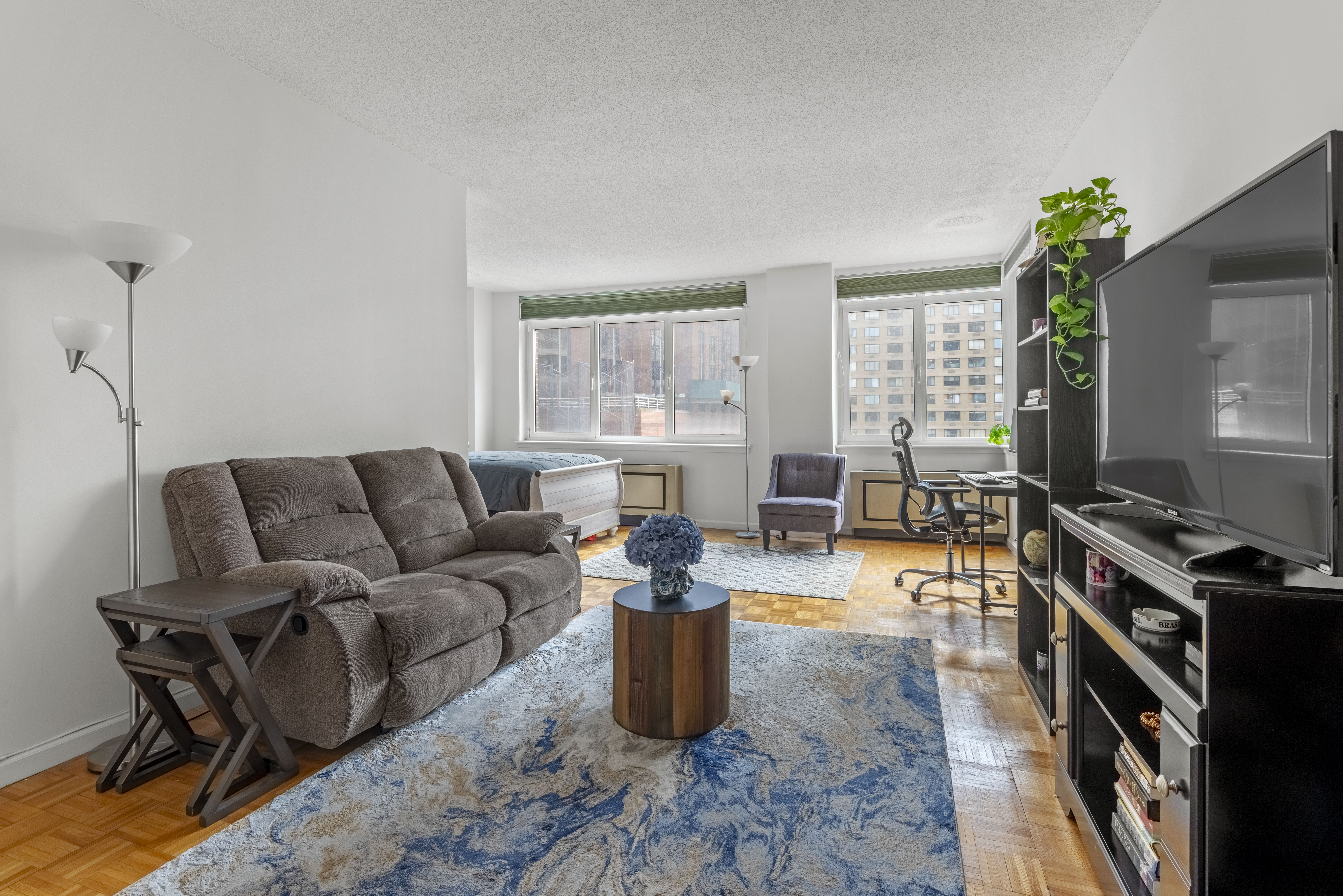 45 West 67th Street, Unit 14D Manhattan, NY 10023 - Photo 8 of 13 a living room with furniture a flat screen tv and a window