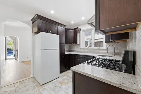 a kitchen with stainless steel appliances granite countertop a sink stove and refrigerator