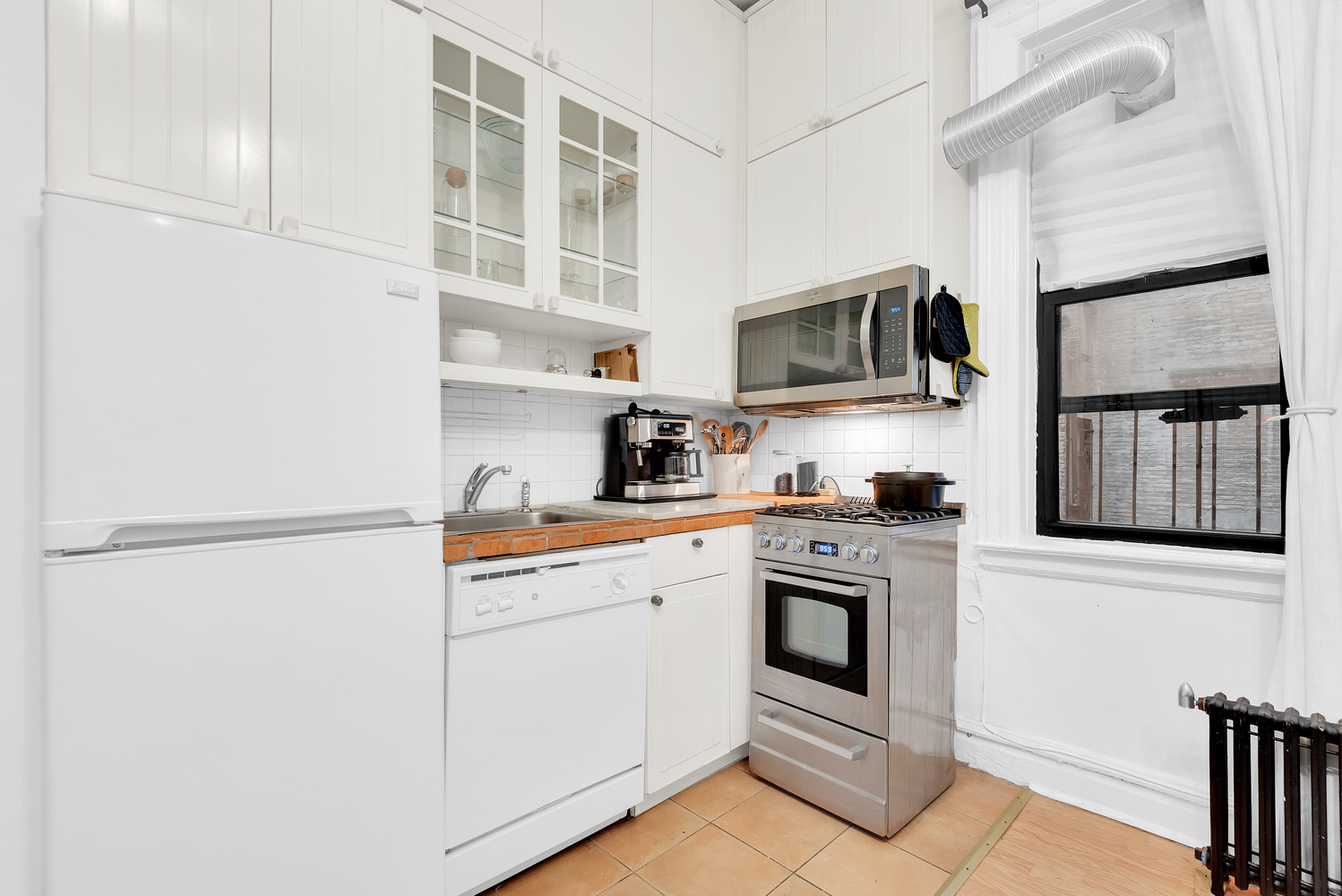 166 East 92nd Street, Unit 1D Manhattan, NY 10128 - Photo 2 of 6 a kitchen with cabinets stainless steel appliances and a counter space