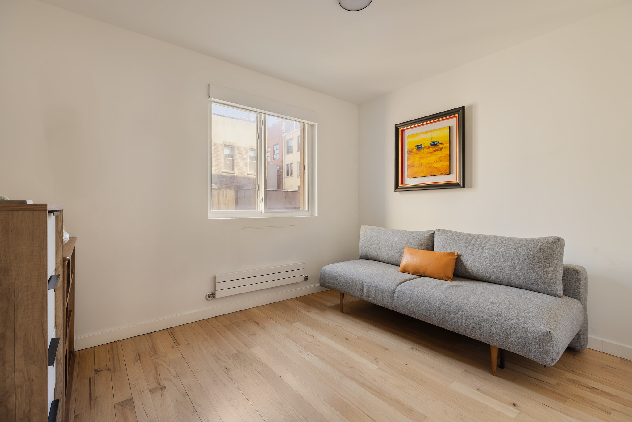 182 Mulberry Street, Unit 4 Manhattan, NY 10012 - Photo 11 of 13 a living room with furniture and a window