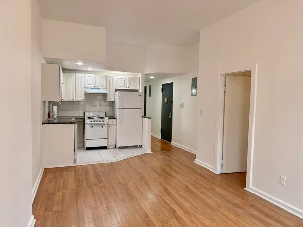 a kitchen with stainless steel appliances a refrigerator and wooden floor